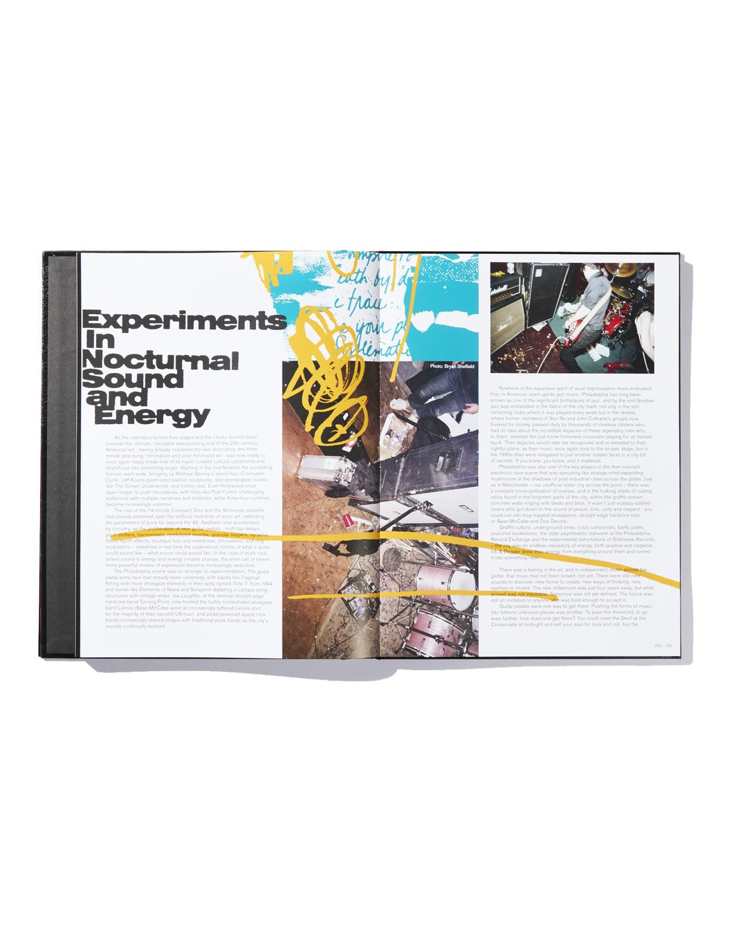 An open book from Ink & Dagger displays an article titled "Experiments in Nocturnal Sound and Energy," accompanied by photos of musical equipment and abstract yellow and blue graphics—featured as part of the limited edition hardcover Ink & Dagger book, "The Almighty Jeremy Dean Erik Bader.