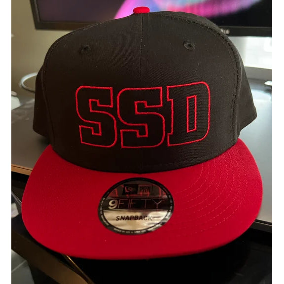 A black and red SS Decontrol New Era Cap with a flat bill, featuring the SSD logo in bold red embroidery on the front and a 9FIFTY SNAPBACK sticker on the brim.