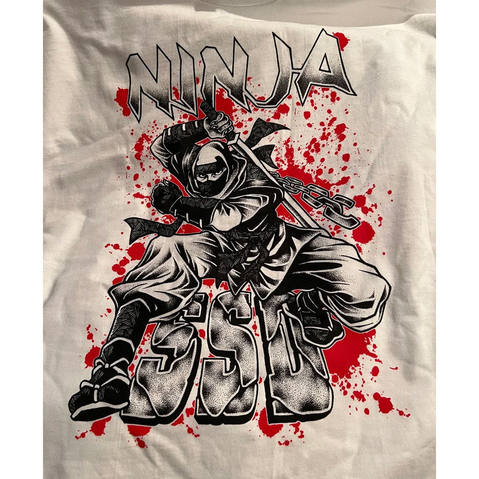 SS Decontrol’s Limited Edition Ninja Tribute Shirt features dynamic ninja art by Kavie Alkaf Imasya, with Ninja above and ESD below on red splatter over white.