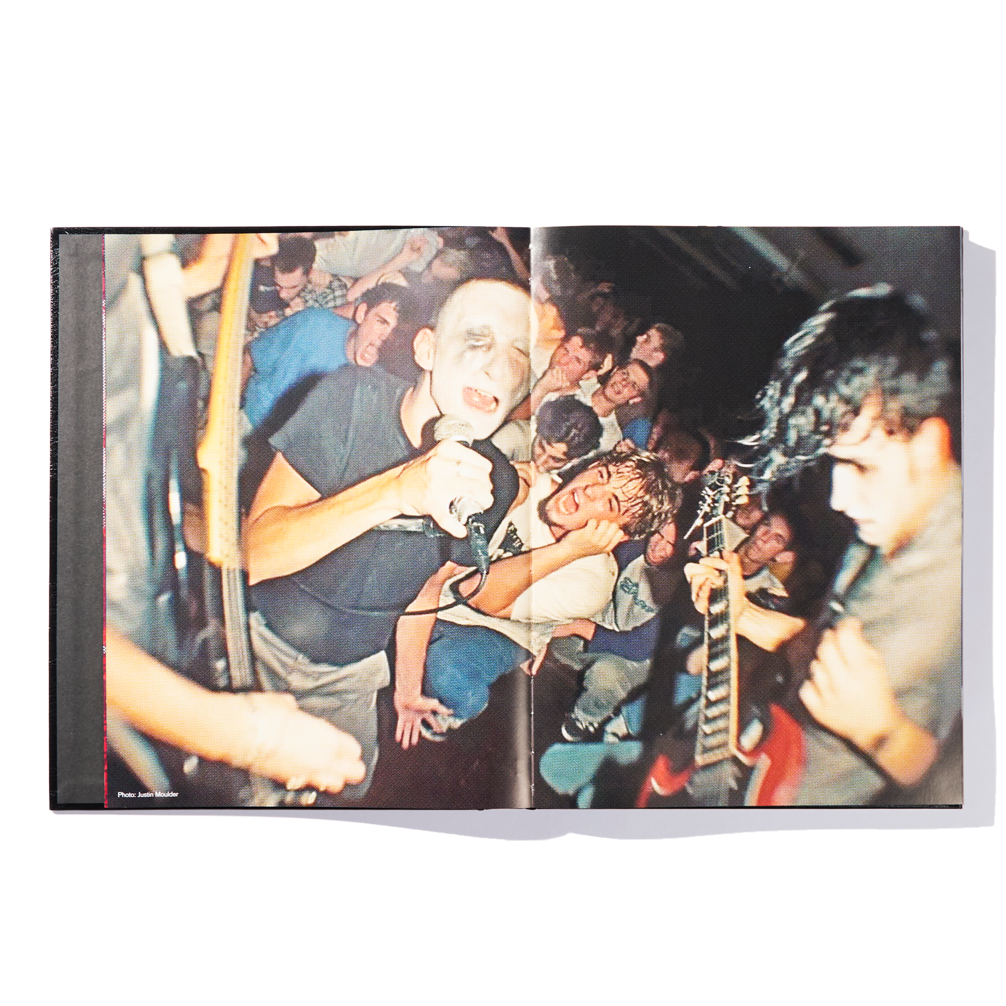 Open book displaying a dynamic photo of a concert crowd, with two musicians from Ink & Dagger performing energetically on stage—one with a microphone and the other playing guitar—surrounded by enthusiastic fans; the perfect moment captured in this exclusive limited edition release.