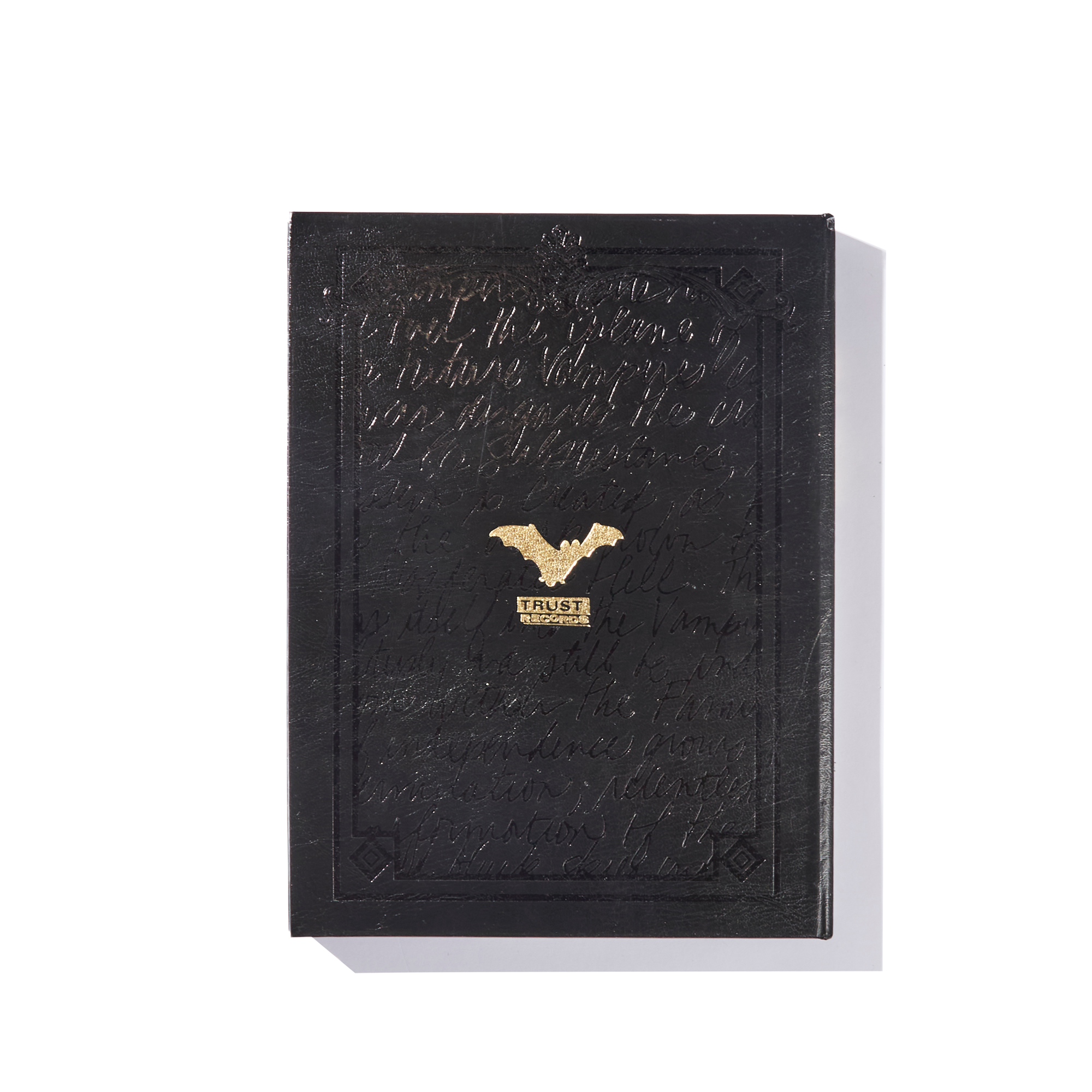 An exclusive limited edition black book from Ink & Dagger, featuring embossed text, a gold bat emblem, and "FRYSE" stamped in gold foil on the cover—photographed against a white background with shadow—known as The Almighty book.