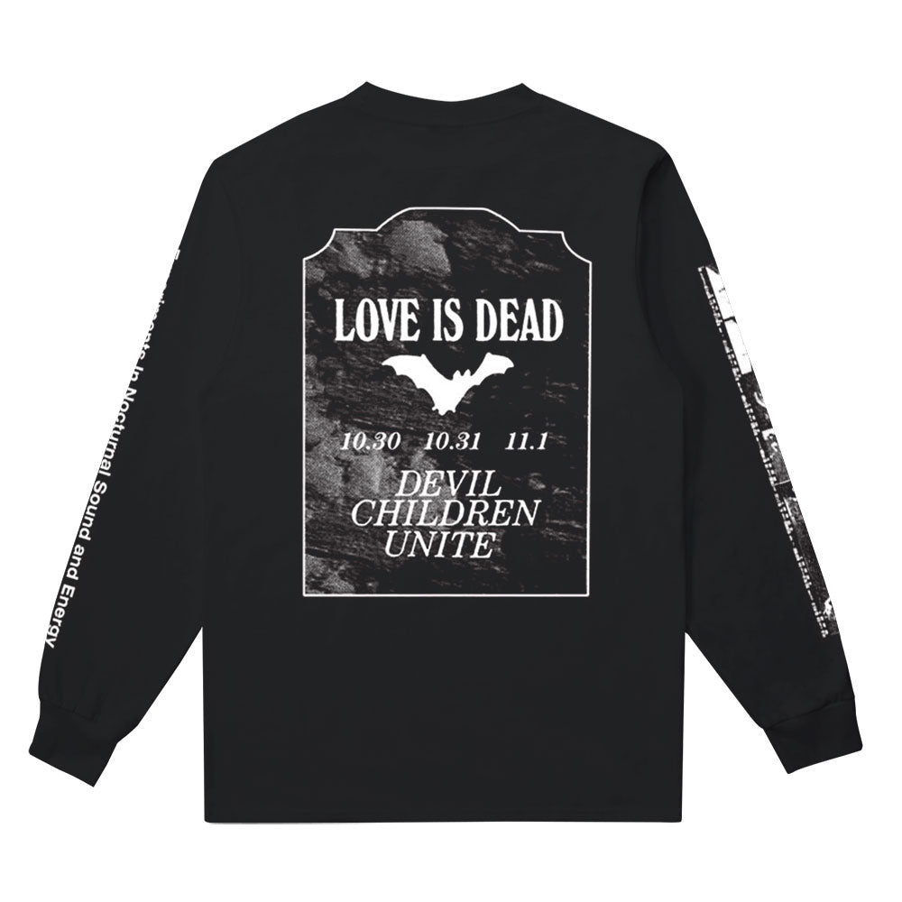 Black long-sleeve Ink & Dagger Comfort Colors shirt featuring a white tombstone-style graphic on the back with "LOVE IS DEAD," dates 10.30, 10.31, 11.1, "DEVIL CHILDREN UNITE" below a bat, and white text along the sleeves.