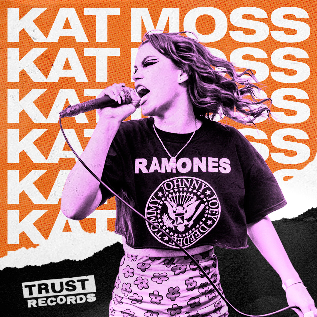 A woman passionately sings into a microphone, wearing a Ramones T-shirt and patterned skirt. KAT MOSS is repeated in bold white text on an orange background. TRUST RECORDS appears in the corner.