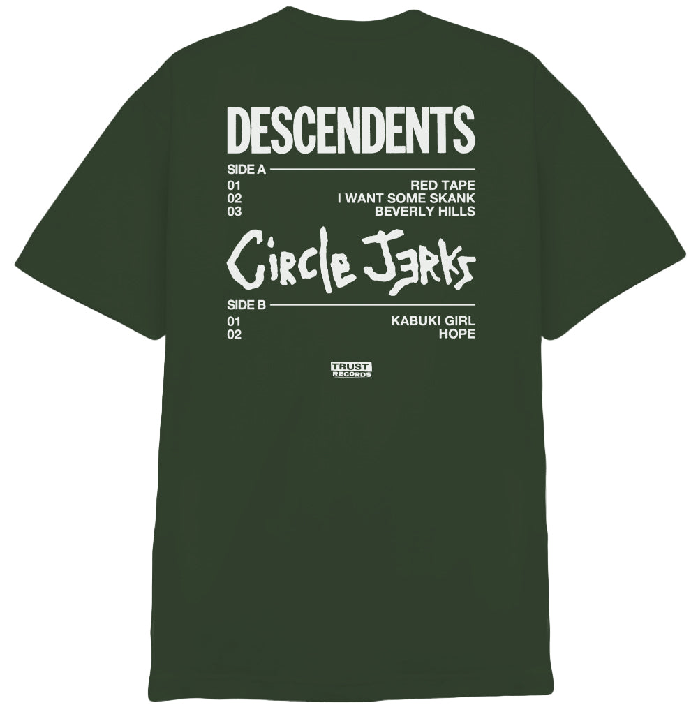 An Ivy Green Circle Jerks T-Shirt with cartoon art of a character holding a broken guitar, DESCENDENTS written vertically, and Circle Jerks in white stylized text on the front. Great for punk fans.