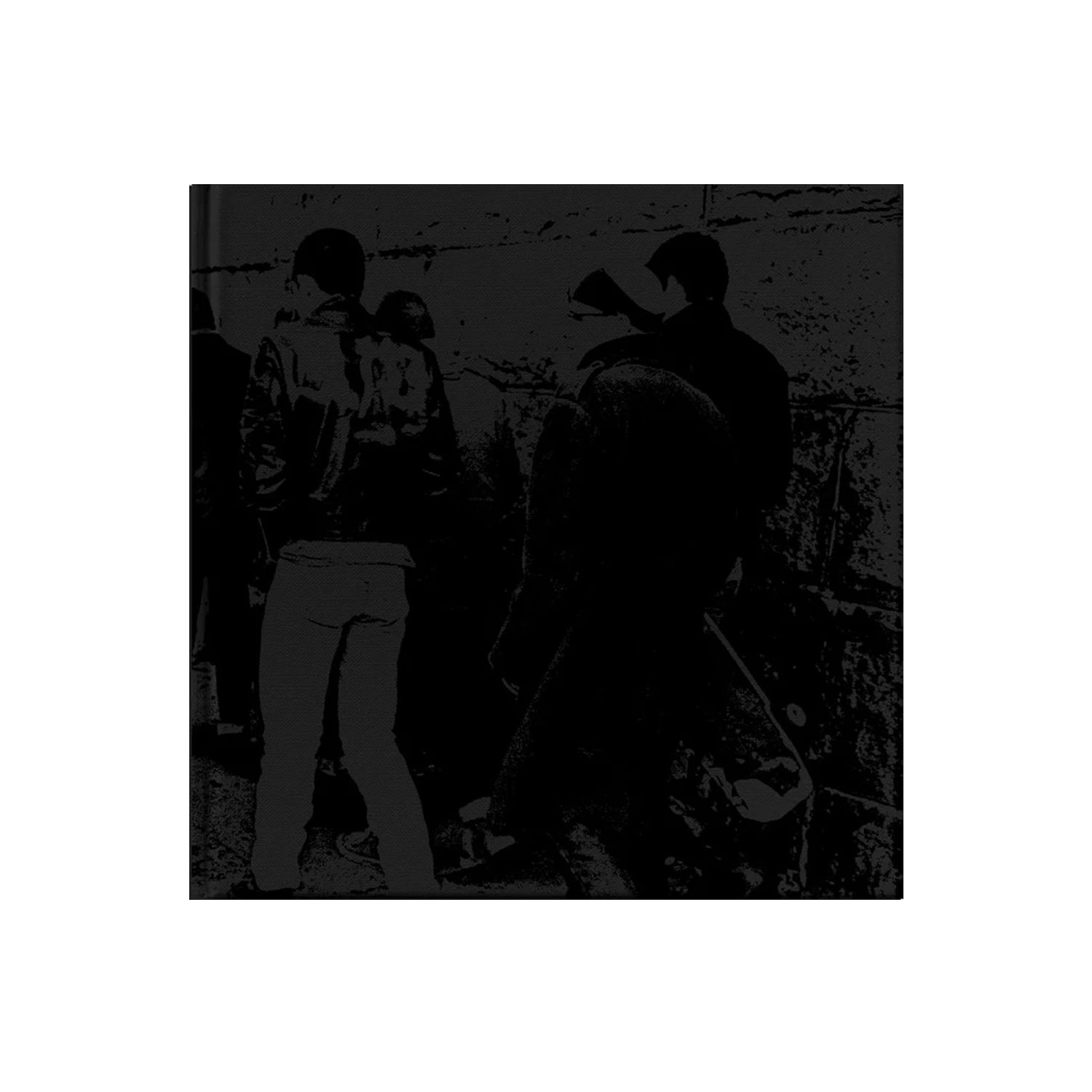 A black and white photo of several people standing together near a wall, featured in the SS Decontrol Art Compilation Book. The candid scene shows some figures partially turned away against a stone or concrete-textured background.