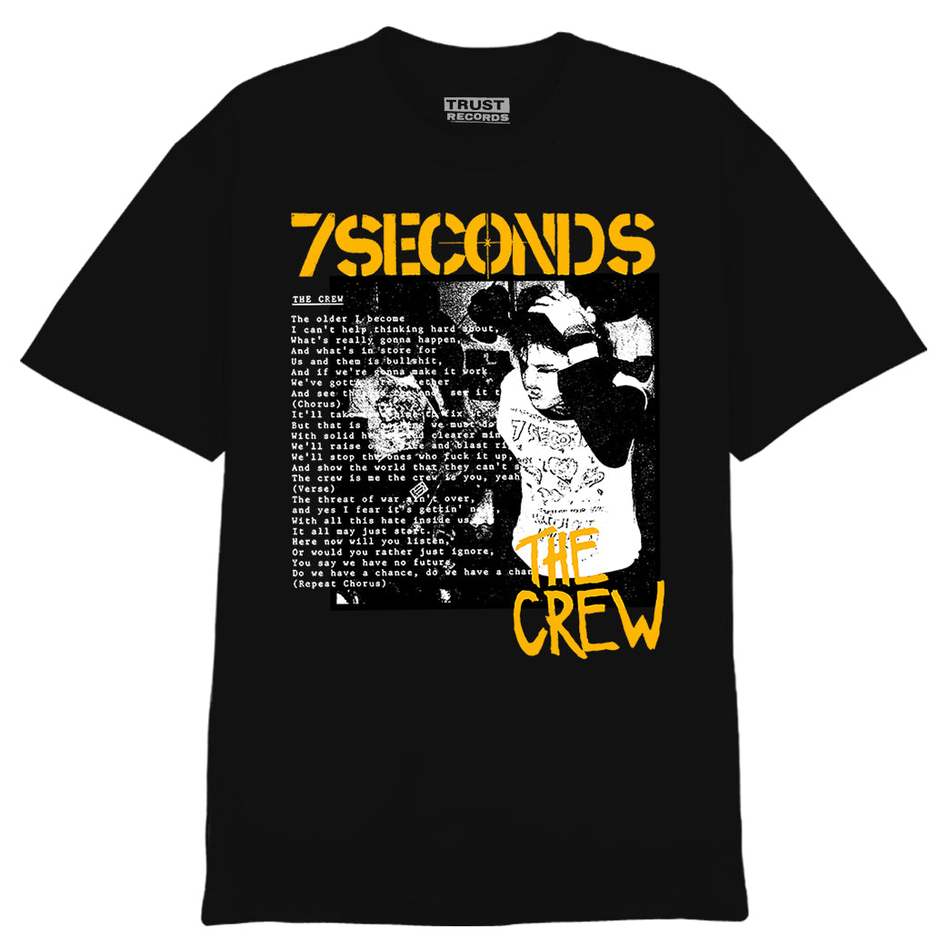 Black 7 Seconds Alstyle 1301 T-shirt with a black-and-white photo of a person wearing headphones, yellow 7SECONDS and THE CREW text, silkscreened white lyrics on the front, and TRUST RECORDS printed inside the collar.