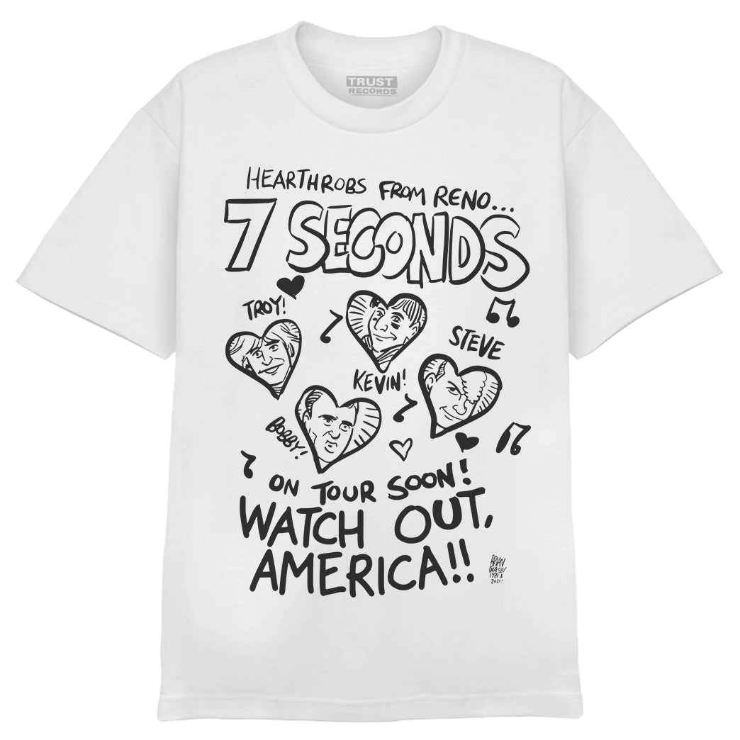 White hand drawn t-shirt by 7 Seconds featuring black cartoon drawings of four men—Troy!, Steve, Bobby!, Kevin!—in heart shapes. Text: Heartthrobs from Reno... 7 Seconds. On tour soon! Trust Records—watch out, America!.