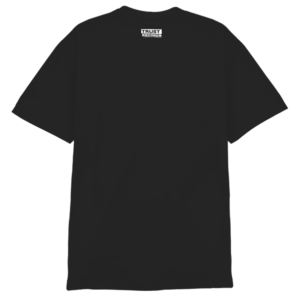 Black short-sleeve T-shirt shown from the back, with a small white TRUST RECORDS logo silkscreened near the neckline. Made from 100% cotton Alstyle 1301 by Better Youth Organization for lasting comfort and durability.