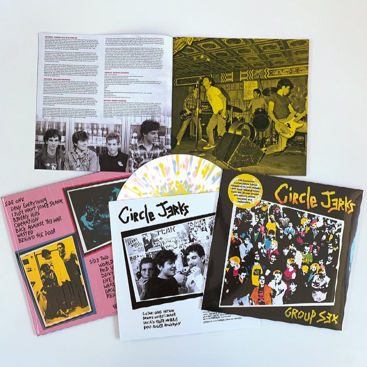 A limited edition Circle Jerks Group Sex 40th Anniversary vinyl box set is displayed, with a splatter vinyl record, lyric booklet, band photos, yellow-black cover, and inserts arranged on a white background.