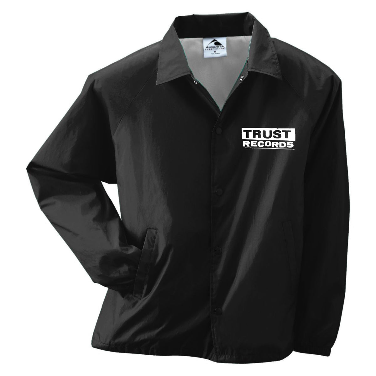A black windbreaker jacket from Trust Records with side pockets, a collar, and the white Trust Records logo on the left chest.